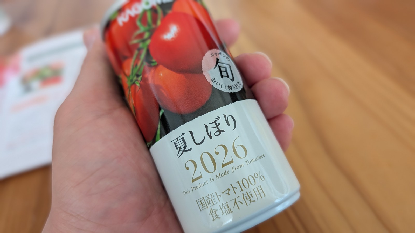 カゴメ「夏しぼり2026」190g缶を手に持ったところ。缶には国産トマト100%・食塩不使用と書かれている