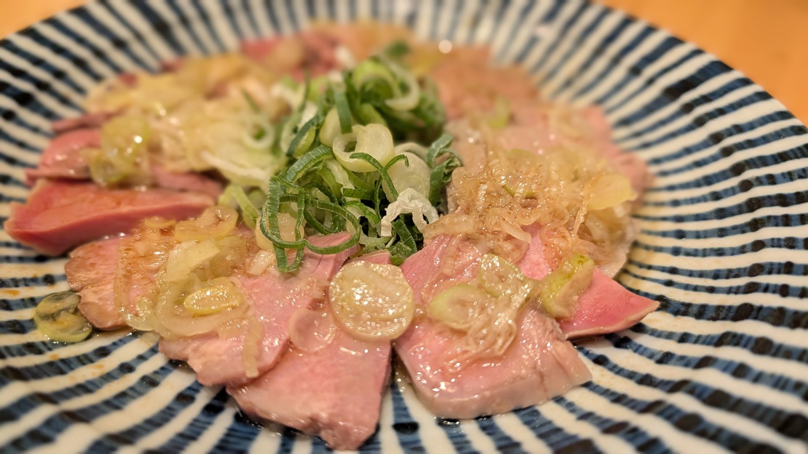 薬味のねぎをたっぷりのせた肉の一皿