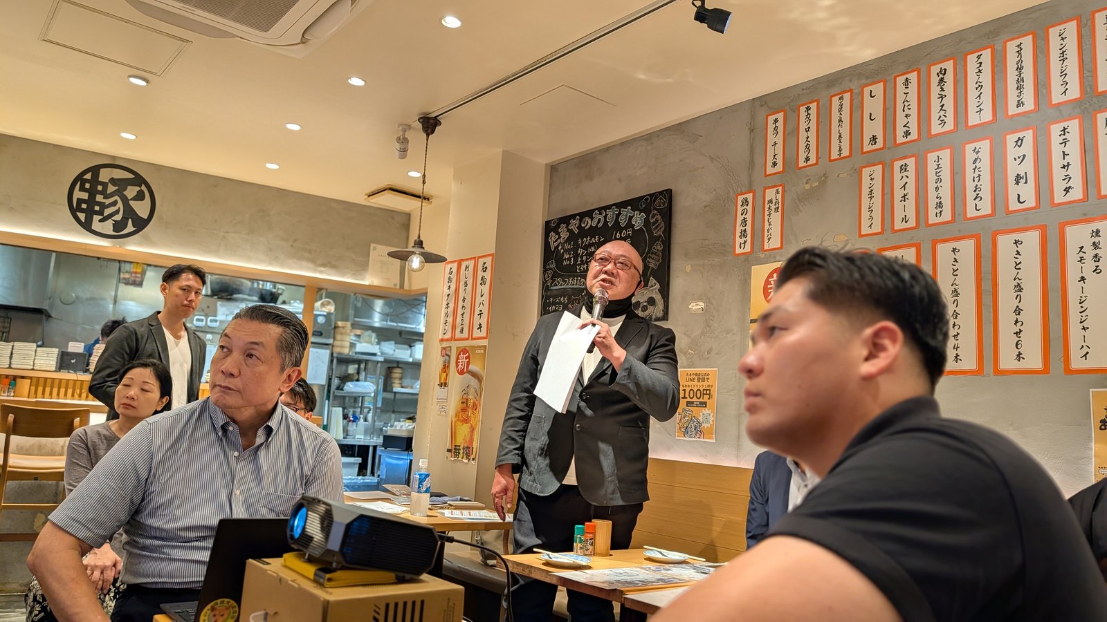 店内で参加者に語りかける田鍋仁章さんと、耳を傾ける参加者