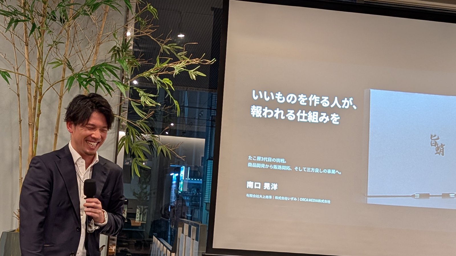 いいものを作る人が、報われる仕組みを、と書かれたスライドの前で笑顔で話す南口晃洋さん