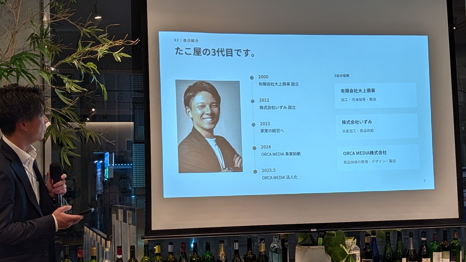 たこ屋の3代目です、と題した自己紹介スライド。大上商事、いずみ、ORCA MEDIAの3社の役割と年表